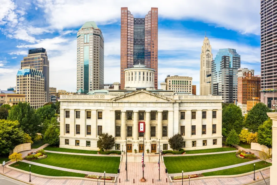 Ohio State Senate building nwith modern downtown Columbus skyscrapers in background.